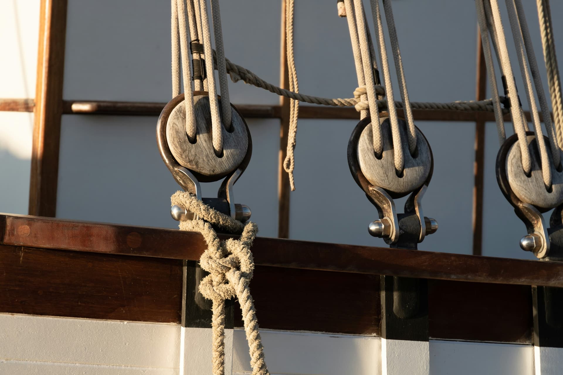 Three swivel blocks with lines running through them, mounted on a sailing boat's rail